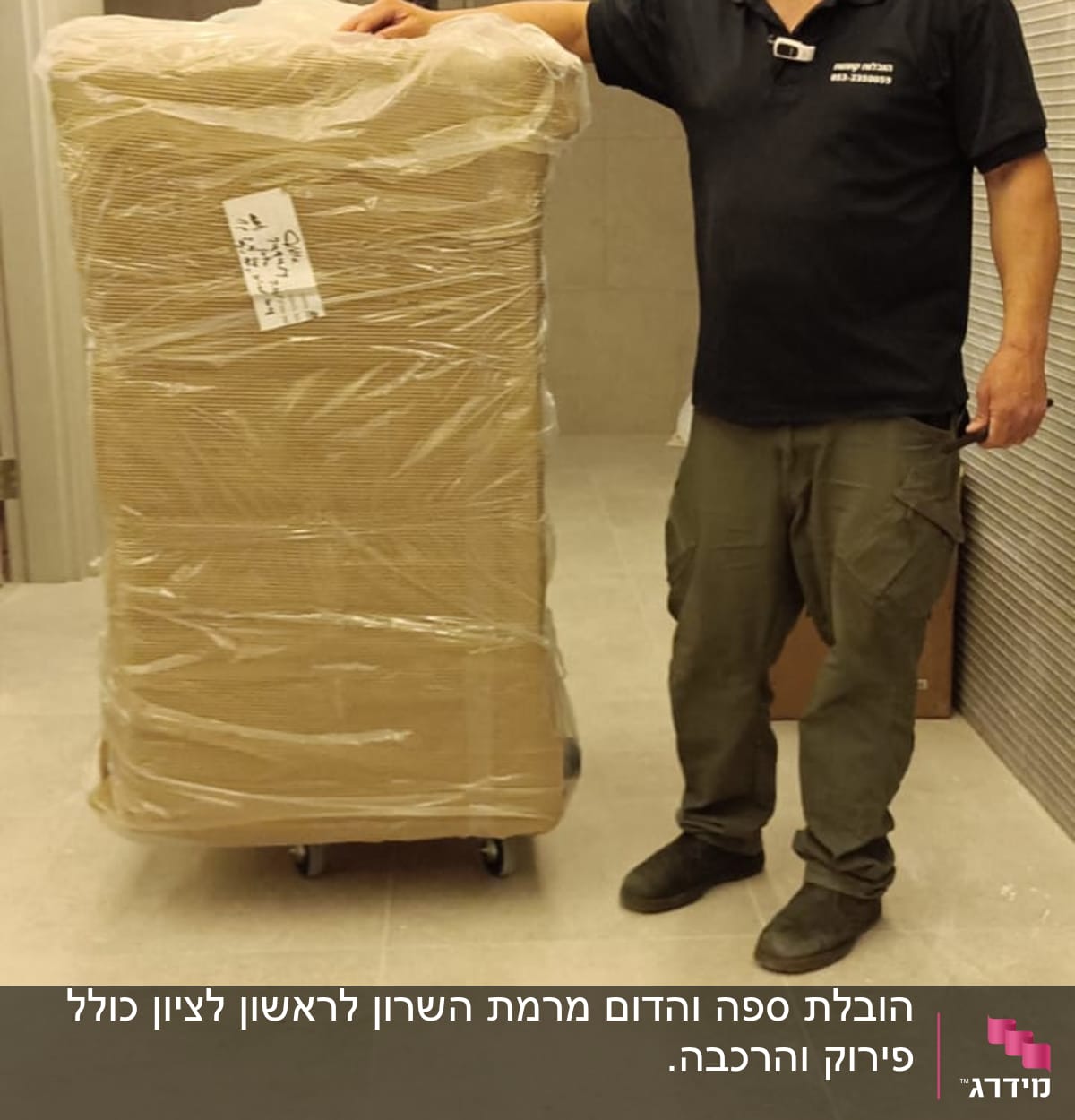 אדם ליד ארגז עטוף בניילון על גלגלים